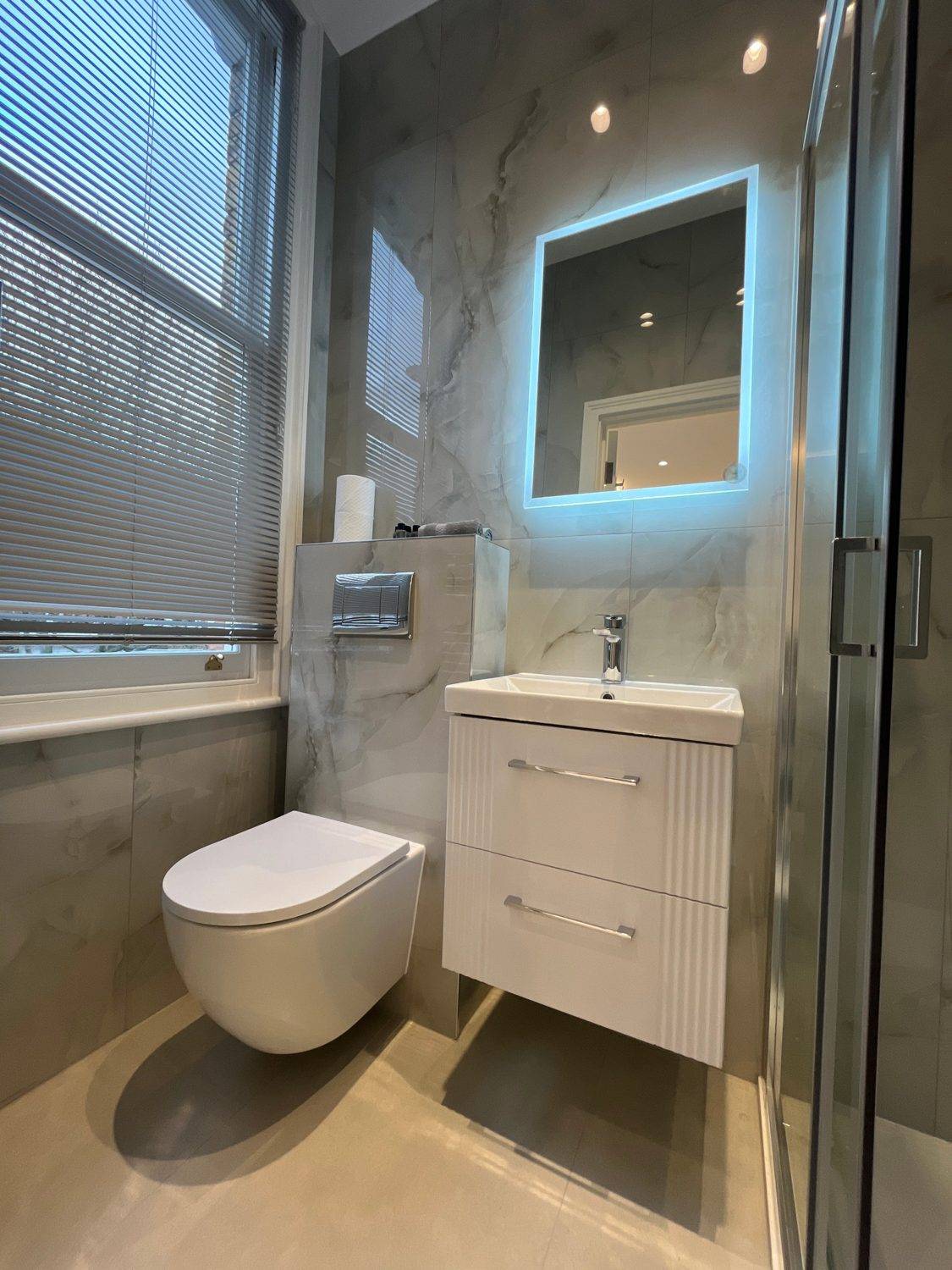 Bathroom with wall-hung WC, vanity unit and LED mirror